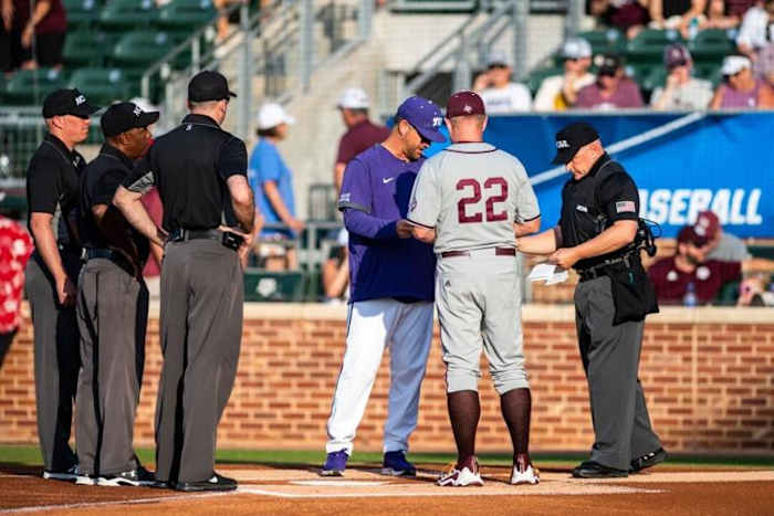 Texas A&M head coach Jim Schlossnagle and TCU head coach Kirk Saarloos meet at home plate before the College Station Regional final.